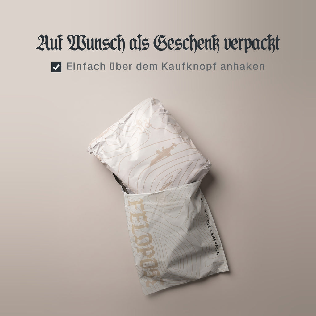 Schriftzug „Auf Wunsch als Geschenk verpackt“, darunter ein angehaktes Kästchen mit „Einfach über dem Kaufknopf anhaken“, über einem Paket in Predator-Customs-Geschenkpapier im Feldpost-Versandbeutel