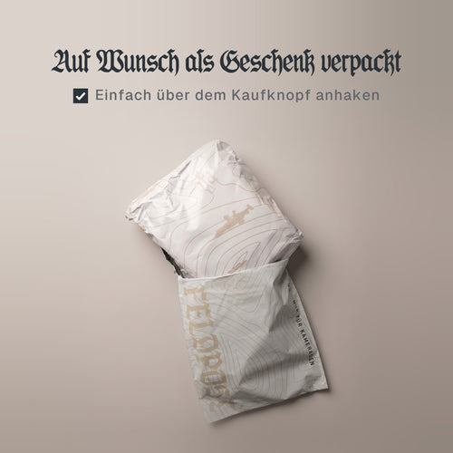 Schriftzug „Auf Wunsch als Geschenk verpackt“, darunter ein angehaktes Kästchen mit „Einfach über dem Kaufknopf anhaken“, über einem Paket in Predator-Customs-Geschenkpapier im Feldpost-Versandbeutel